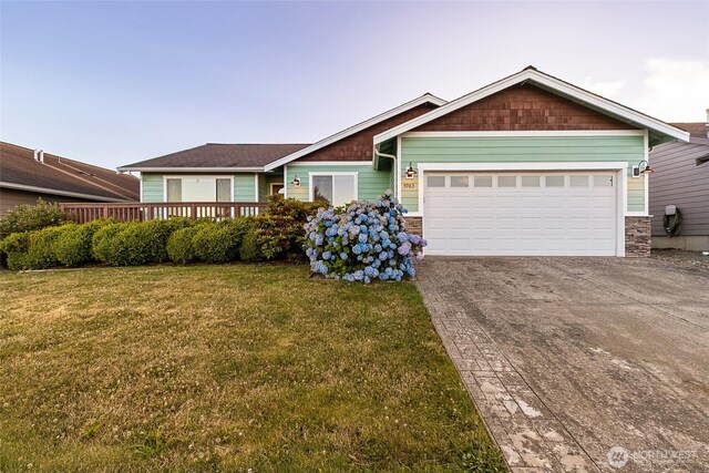 5983 Honeycutt Ct, Ferndale, WA 98248 - craftsman house featuring concrete driveway, a front yard, a garage, a wooden deck, and stone siding