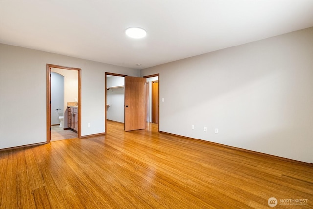 5983 Honeycutt Ct, Ferndale, WA 98248 - unfurnished bedroom with a spacious closet, light wood finished floors, connected bathroom, and a closet