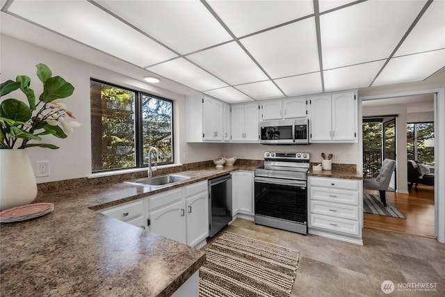 13573 Linden Ave N Unit 302, Seattle, WA 98133 - kitchen with appliances with stainless steel finishes, dark countertops, and white cabinets