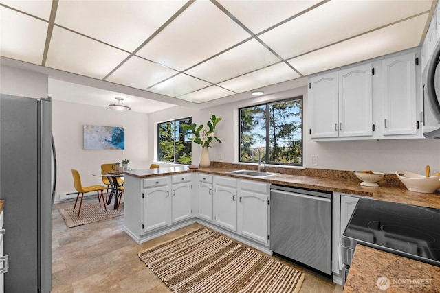 13573 Linden Ave N Unit 302, Seattle, WA 98133 - kitchen featuring stainless steel appliances, a peninsula, baseboard heating, white cabinets, and dark countertops