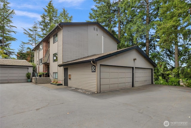 13573 Linden Ave N Unit 302, Seattle, WA 98133 - view of property exterior featuring a garage and an outdoor structure
