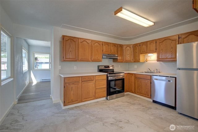 408 N 11th St, Elma, WA 98541 - kitchen featuring stainless steel appliances, under cabinet range hood, light countertops, light marble finish flooring, and a baseboard radiator