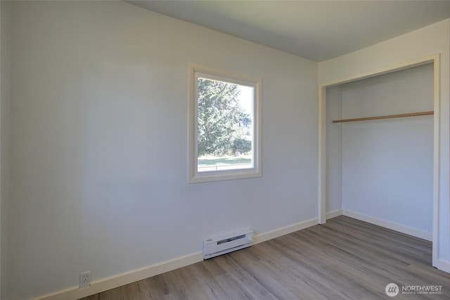 408 N 11th St, Elma, WA 98541 - unfurnished bedroom with a baseboard heating unit, wood finished floors, and a closet