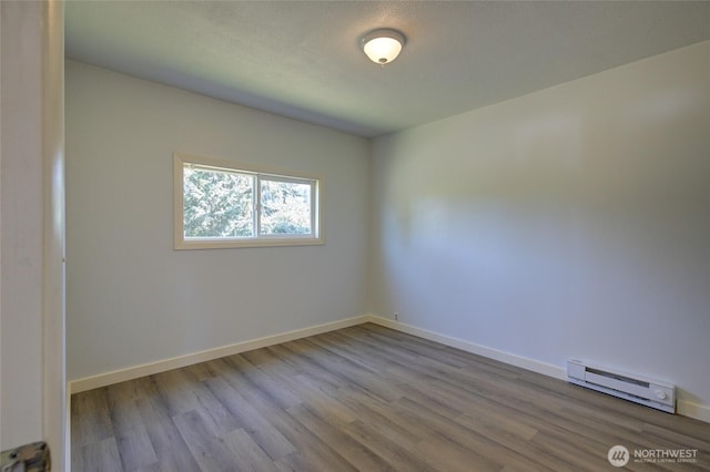 408 N 11th St, Elma, WA 98541 - empty room featuring a baseboard heating unit and wood finished floors