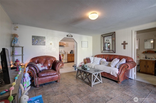 408 N 11th St, Elma, WA 98541 - living area featuring arched walkways, a textured ceiling, stone finish floors, and ornamental molding