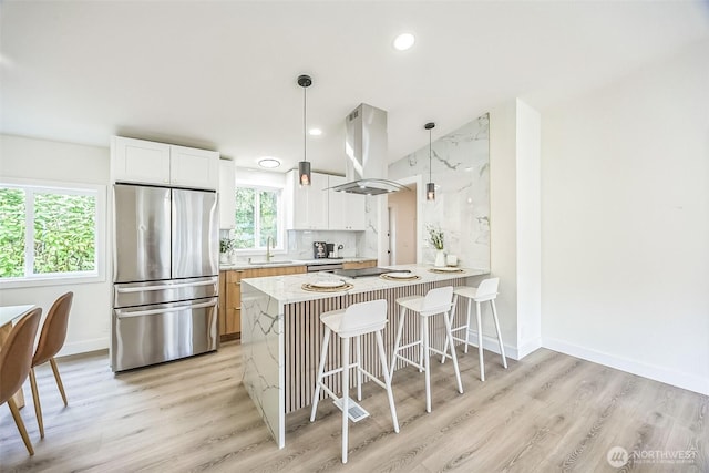 1322 Crescent Ave, Centralia, WA 98531 - kitchen featuring appliances with stainless steel finishes, island exhaust hood, light wood-style floors, a peninsula, and a breakfast bar area