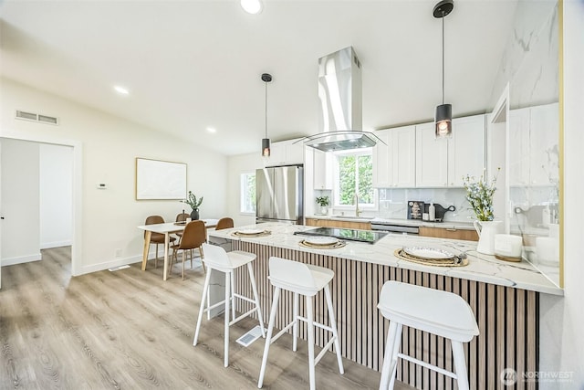 1322 Crescent Ave, Centralia, WA 98531 - kitchen with appliances with stainless steel finishes, island exhaust hood, lofted ceiling, a breakfast bar, and decorative light fixtures