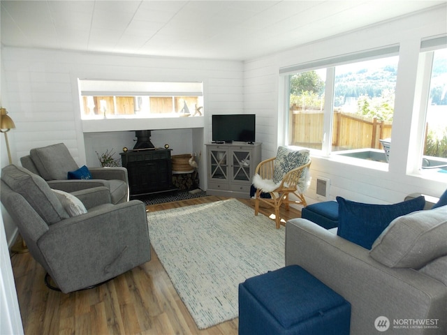 3223 Aspinwall Rd NW, Olympia, WA 98502 - living area featuring a wood stove, wood finished floors, and wood walls