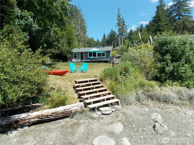 3223 Aspinwall Rd NW, Olympia, WA 98502 - rear view of house with a deck, view of wooded area, and a lawn
