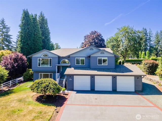 7332 156th St SE, Snohomish, WA 98296 - split foyer home featuring asphalt driveway, a garage, stairs, and a shingled roof