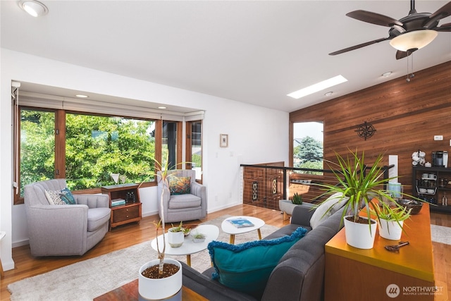 14785 Channel Dr, La Conner, WA 98257 - living area with ceiling fan, wood walls, wood finished floors, a skylight, and recessed lighting