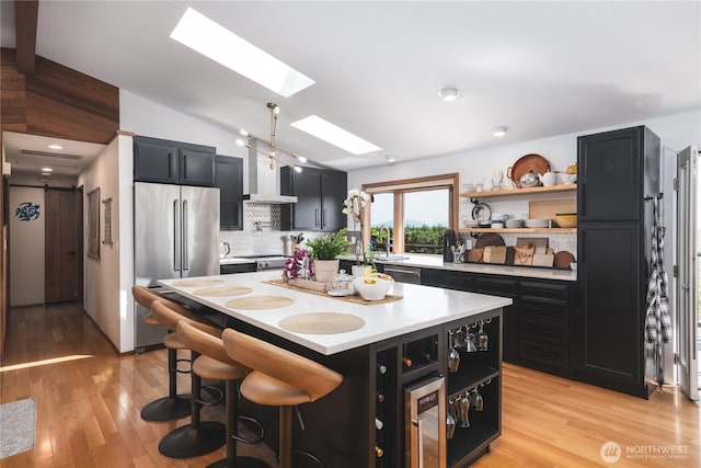 14785 Channel Dr, La Conner, WA 98257 - kitchen with appliances with stainless steel finishes, dark cabinetry, a skylight, light countertops, and vaulted ceiling