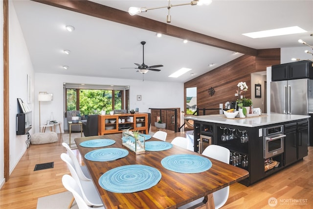 14785 Channel Dr, La Conner, WA 98257 - dining room featuring ceiling fan, light wood-type flooring, and wood walls