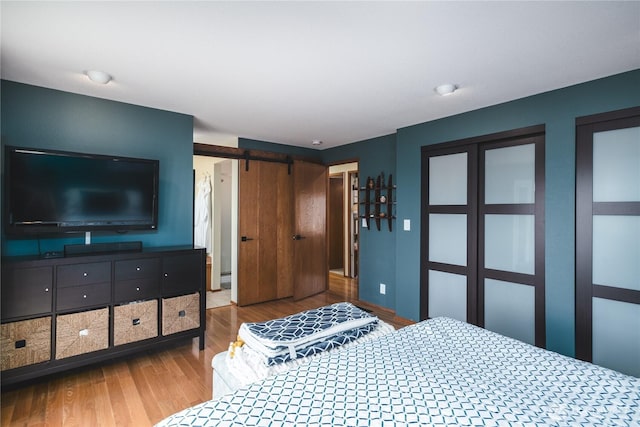 14785 Channel Dr, La Conner, WA 98257 - bedroom featuring wood finished floors and a barn door