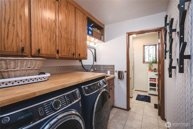 14785 Channel Dr, La Conner, WA 98257 - washroom featuring cabinet space, washer and dryer, and light tile patterned flooring