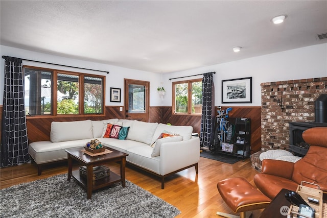14785 Channel Dr, La Conner, WA 98257 - living area featuring a wainscoted wall, a wood stove, wood walls, and wood finished floors