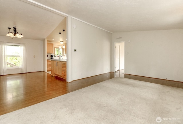1106 29th St SE, Auburn, WA 98002 - unfurnished living room with a chandelier, wood finished floors, carpet, and vaulted ceiling