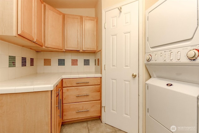 1106 29th St SE, Auburn, WA 98002 - laundry area with stacked washer and clothes dryer, cabinet space, and light tile patterned floors