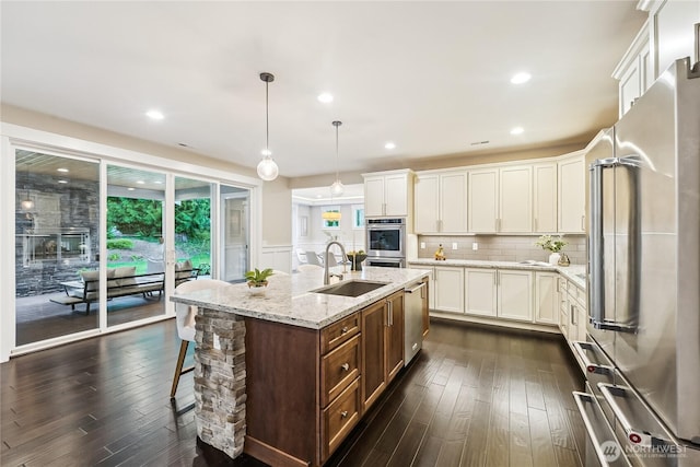 24130 145th Ave SE, Snohomish, WA 98296 - kitchen with stainless steel appliances, dark wood-type flooring, white cabinetry, a center island with sink, and wainscoting