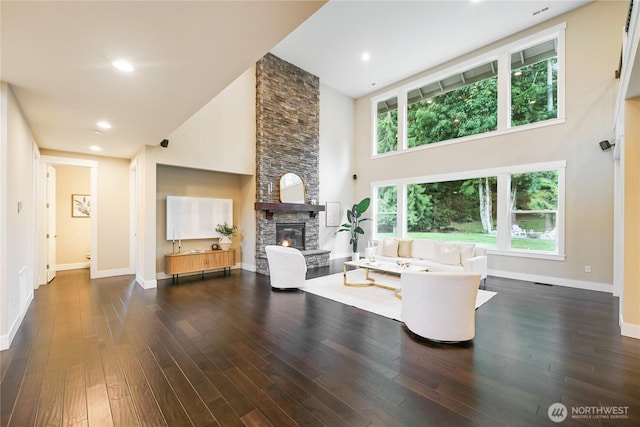 24130 145th Ave SE, Snohomish, WA 98296 - living area featuring a towering ceiling, a stone fireplace, and dark wood-style floors