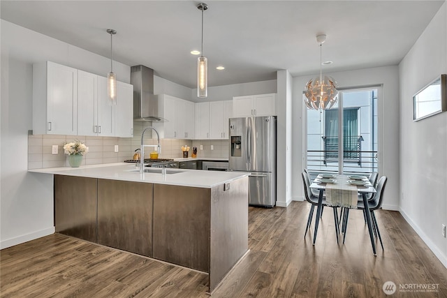 8537 22nd Pl NE, Seattle, WA 98115 - kitchen featuring stainless steel fridge, wall chimney exhaust hood, a chandelier, a peninsula, and light countertops