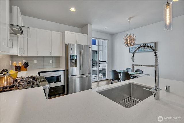 8537 22nd Pl NE, Seattle, WA 98115 - kitchen with appliances with stainless steel finishes, light countertops, backsplash, white cabinetry, and hanging light fixtures