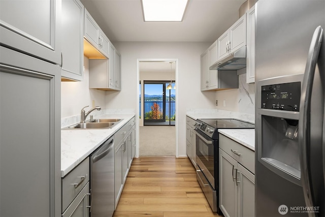 8005 Sand Point Way NE Unit A52, Seattle, WA 98115 - kitchen with stainless steel appliances, under cabinet range hood, gray cabinets, and light wood-style flooring