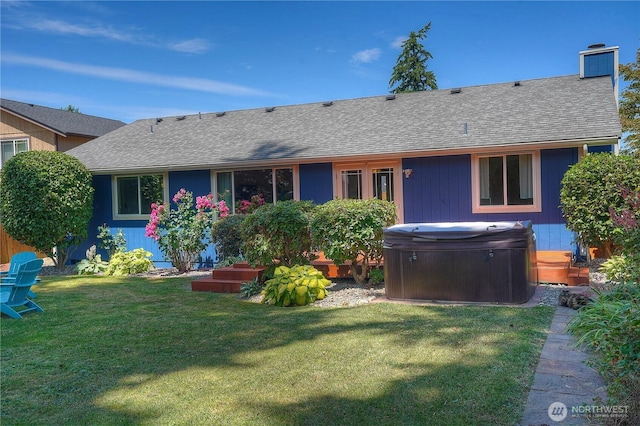 1717 SW 347th Pl, Federal Way, WA 98023 - back of house with a hot tub, roof with shingles, a chimney, and a lawn
