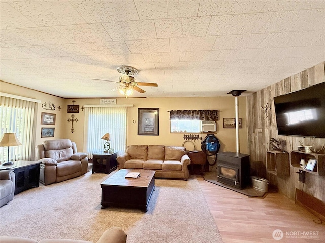 15 S Heise Rd, Elma, WA 98541 - living room with a wood stove, ceiling fan, wood finished floors, and wood walls
