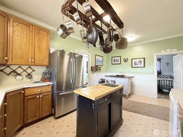15 S Heise Rd, Elma, WA 98541 - kitchen with freestanding refrigerator, light floors, crown molding, brown cabinets, and wainscoting