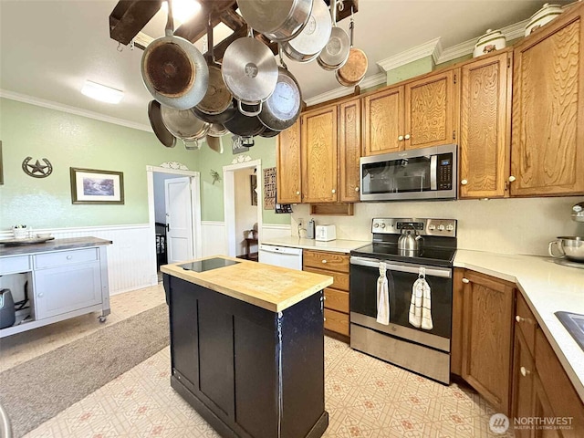 15 S Heise Rd, Elma, WA 98541 - kitchen featuring stainless steel appliances, crown molding, wooden counters, light flooring, and brown cabinets