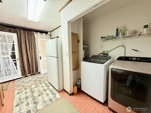 15 S Heise Rd, Elma, WA 98541 - laundry area featuring washer and clothes dryer, a textured ceiling, light tile patterned floors, and electric water heater
