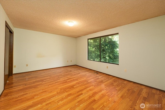 18707 25th Ave NE, Lake Forest Park, WA 98155 - unfurnished room featuring light wood-style floors and a textured ceiling