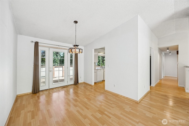 2810 Brentwood Dr SE, Lacey, WA 98503 - unfurnished room featuring light wood-style flooring, vaulted ceiling, a chandelier, and a textured ceiling