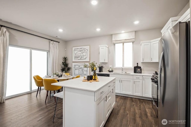 1713 Noble Ave Unit 76, Snohomish, WA 98290 - kitchen with freestanding refrigerator, white cabinets, healthy amount of natural light, a breakfast bar, and recessed lighting