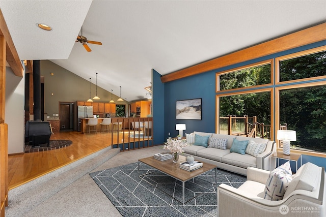 2515 87th Avenue Ct E, Edgewood, WA 98371 - living area with ceiling fan, a wood stove, carpet floors, and high vaulted ceiling
