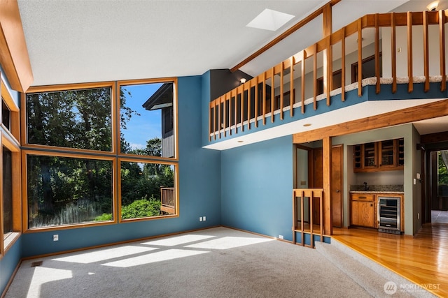 2515 87th Avenue Ct E, Edgewood, WA 98371 - unfurnished living room with beverage cooler, wet bar, lofted ceiling, and carpet flooring