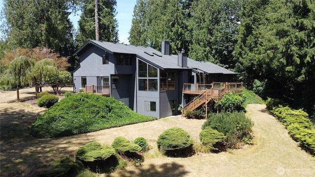 2515 87th Avenue Ct E, Edgewood, WA 98371 - back of house with stairway, a chimney, a wooden deck, and a sunroom