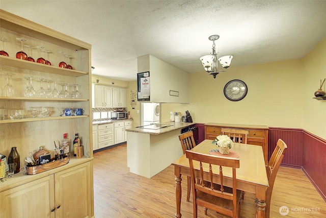 17003 53rd Ave S, Seatac, WA 98188 - dining room with light wood-style flooring, a chandelier, and a wainscoted wall