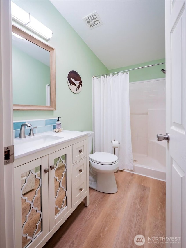 4805 Cushman Rd NE Unit 115, Olympia, WA 98506 - full bathroom featuring wood finished floors, vanity, lofted ceiling, and curtained shower