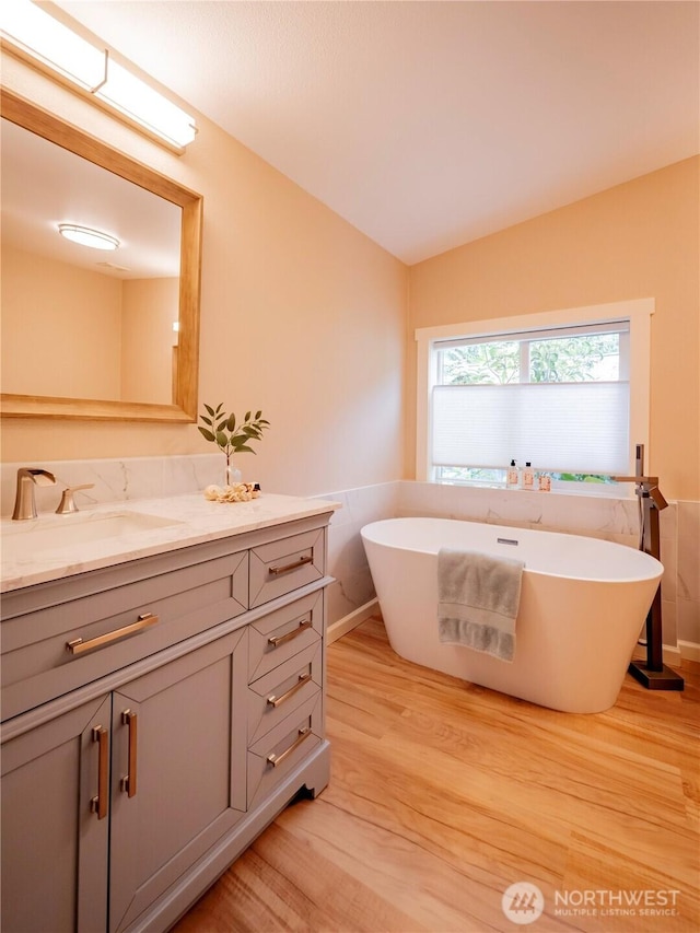 4805 Cushman Rd NE Unit 115, Olympia, WA 98506 - full bathroom featuring wood finished floors, vanity, a freestanding tub, and vaulted ceiling