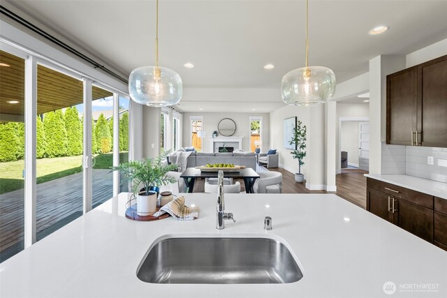605 26th Avenue Ct, Milton, WA 98354 - kitchen featuring light countertops, dark brown cabinetry, recessed lighting, hanging light fixtures, and a fireplace