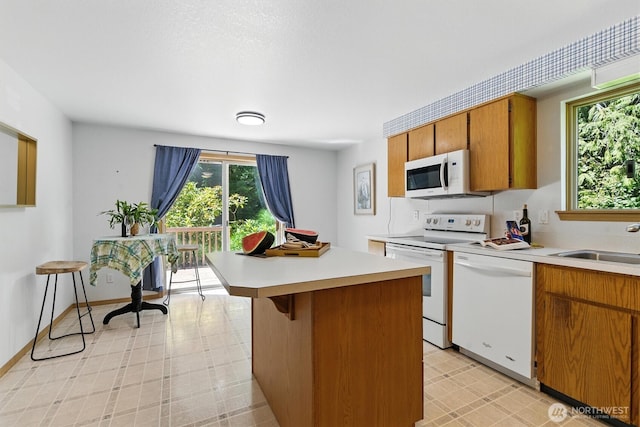 127 E Barnacle Blvd, Shelton, WA 98584 - kitchen featuring white appliances, light countertops, brown cabinetry, and a kitchen island