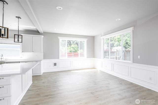 7830 A St, Tacoma, WA 98408 - unfurnished dining area featuring beam ceiling, wainscoting, light wood-type flooring, recessed lighting, and a decorative wall