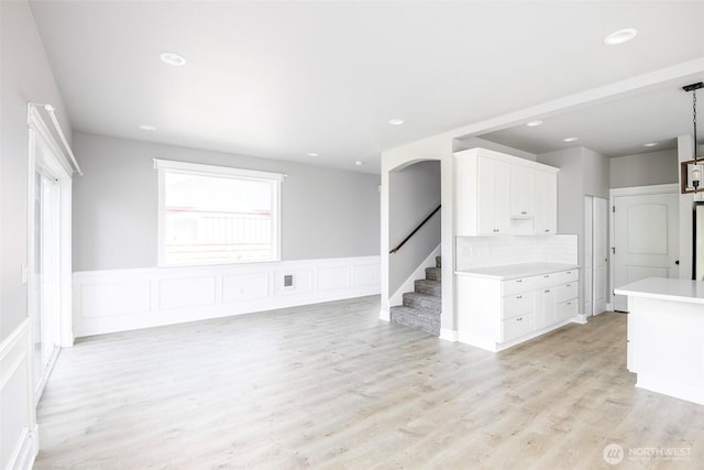 7830 A St, Tacoma, WA 98408 - unfurnished living room featuring light wood finished floors, stairs, wainscoting, recessed lighting, and a decorative wall