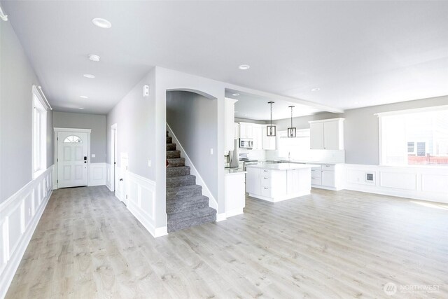 7830 A St, Tacoma, WA 98408 - unfurnished living room featuring a decorative wall, stairs, light wood finished floors, a wainscoted wall, and recessed lighting
