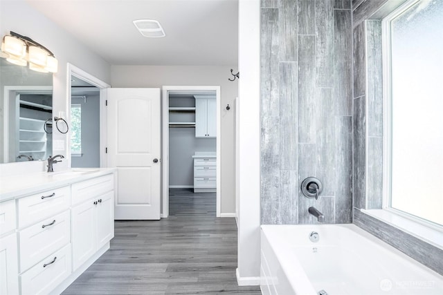 7830 A St, Tacoma, WA 98408 - bathroom featuring vanity, wood finished floors, washtub / shower combination, and a spacious closet