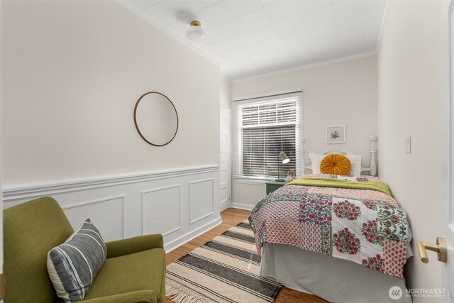 4506 46th Ave SW, Seattle, WA 98116 - bedroom featuring ornamental molding, light wood-style flooring, and a wainscoted wall