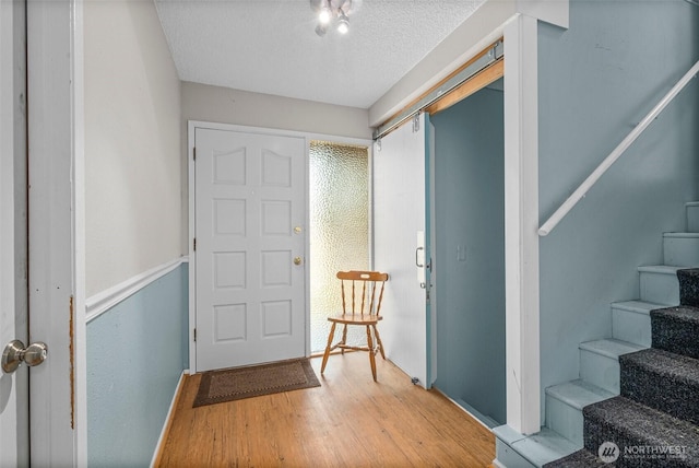 3302 W Tapps Dr E, Lake Tapps, WA 98391 - entrance foyer with stairs, wood finished floors, and a textured ceiling