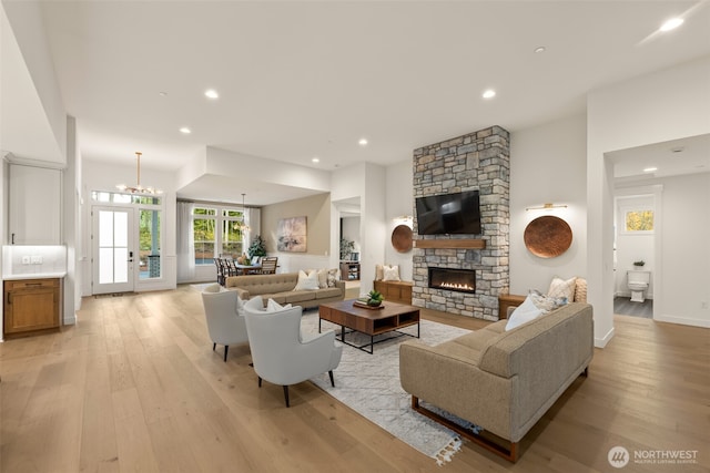 332 138th Pl SE, Auburn, WA 98092 - living area featuring light wood-style flooring, a stone fireplace, recessed lighting, and a chandelier